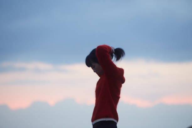 istock woman and the sunset clouds 887436658