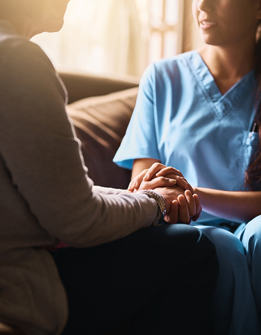 Cropped shot of a nurse holding a senior woman's hands in comfort