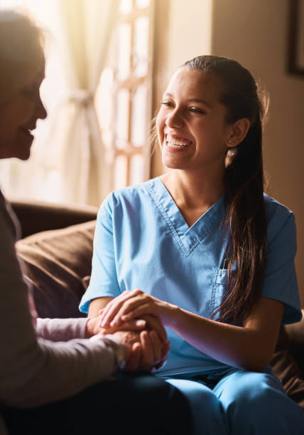 she enjoys interacting with the elderly - senior adult hospital uniform gray hair imagens e fotografias de stock