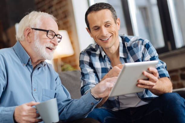 istock Elderly man and his son discussing online article 887442614