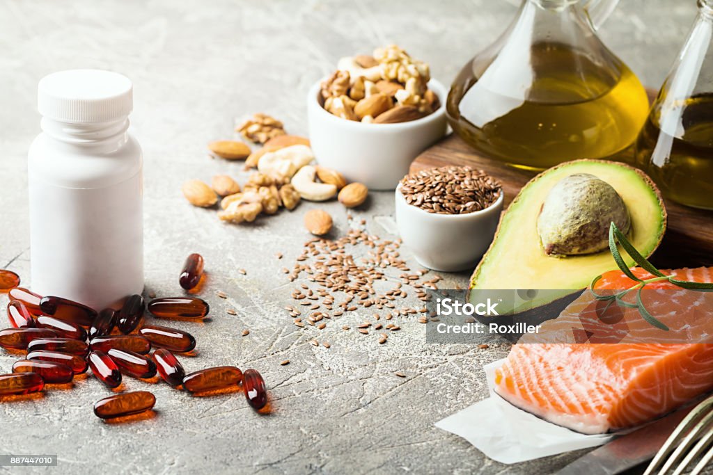 Healthy fats in nutrition. Healthy fats in nutrition - salmon, avocado, oil, nuts. Concept of healthy food Nutritional Supplement Stock Photo