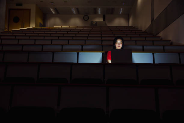 Woman Working Alone in a Seminar Room in the Dark