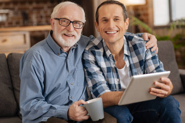 istock Upbeat man surfing the web together with his elderly man 887447280