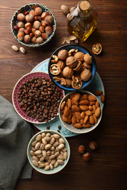 istock Assorted nuts in bowls on wood background 887449050