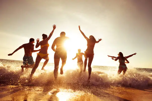 Photo of Big company of friends having fun at sunset beach
