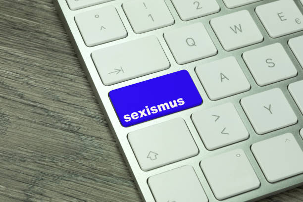 istock A computer and a button with the word sexism 887464416