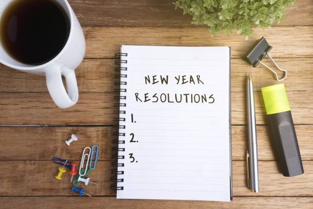 istock New Year Resolutions on Notepad, Coffee and Office Supplies on Wooden background 887470690