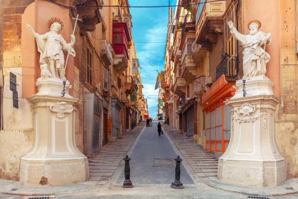 Decorated street in old town of Valletta, Malta The traditional Maltese street stairs with corners of houses, decorated with statues of saints St. John and St. Paul and building with colorful balconies in Valletta, Capital city of Malta valletta photos stock pictures, royalty-free photos & images