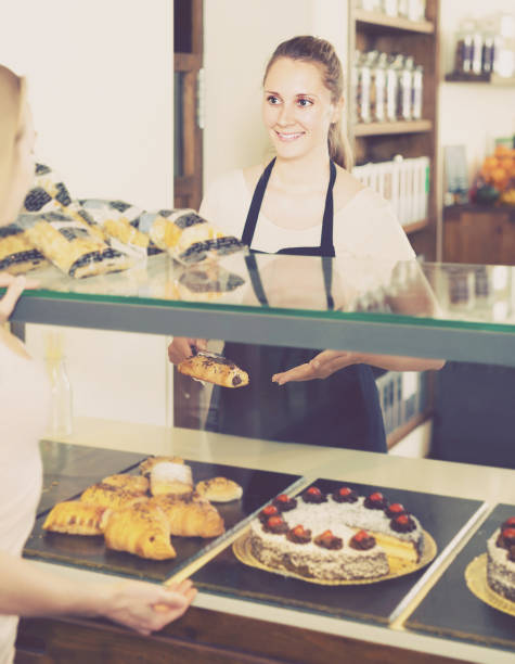 istock Bakery female worker with delicious pies and rolls on counter 887476172