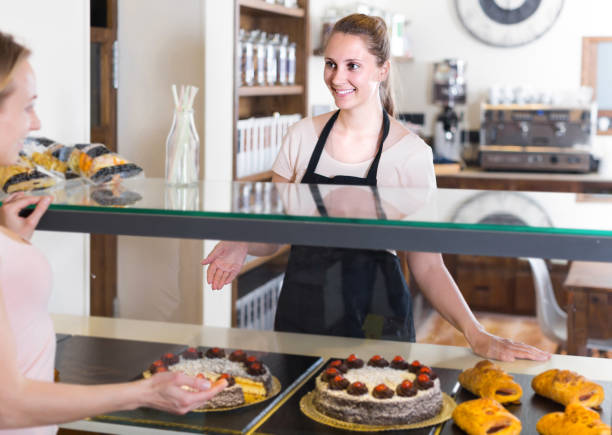istock Bakery female worker with delicious pies and rolls on counter 887476538