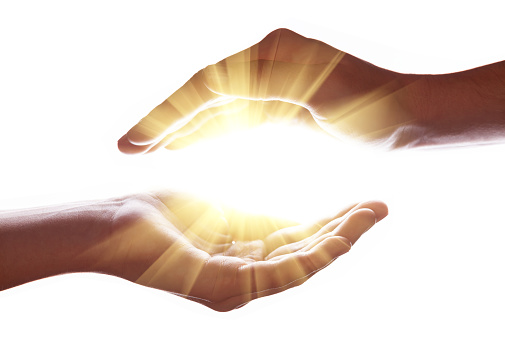 Woman hands protecting and containing bright, glowing, radiant, shining light.