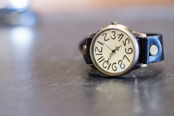 istock Old wrist watch on black stone table with blurry background 887480382