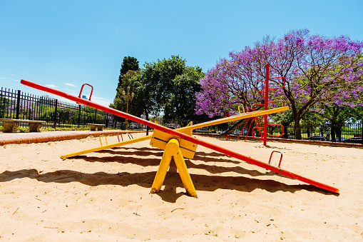 Colorful seesaw viewed from the side in the sandbox of a park
