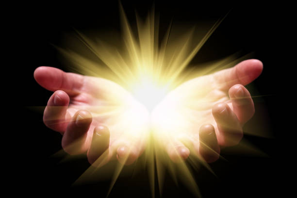 istock Woman hands cupped holding, showing, or emanating bright, glowing, radiant, shining light. 887480740