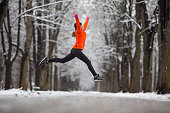 Jump! - side view woman jumping for joy in winter