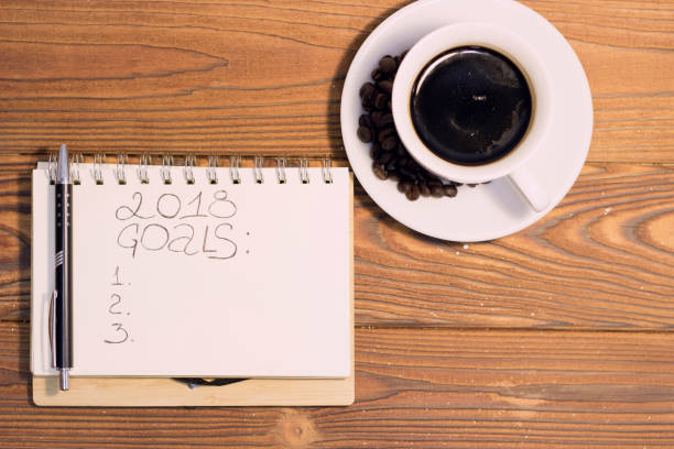 istock A coffee cup with a notebook on a wooden background 887491532