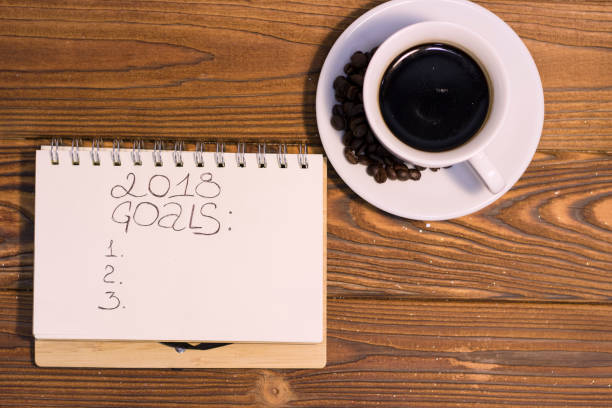 istock A coffee cup with a notebook on a wooden background 887493912