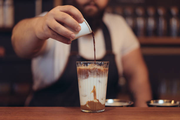 istock Man hand pouring milk in coffee 887494684
