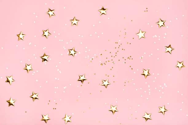 Golden stars glitter on pink background. Golden stars glitter on pink background. Festive holiday pastel backdrop. femininity photos stock pictures, royalty-free photos & images