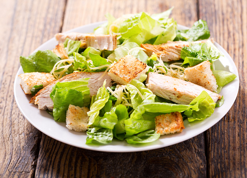 plate of chicken salad on a wooden table