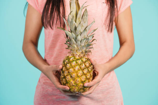 istock Female hand holding ripe pineapple 887517260