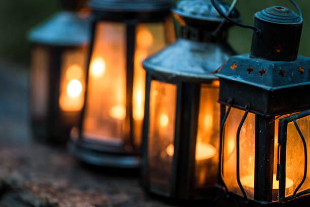 istock Close up of illuminated antique lanterns lit by candlelight in a row 887522232