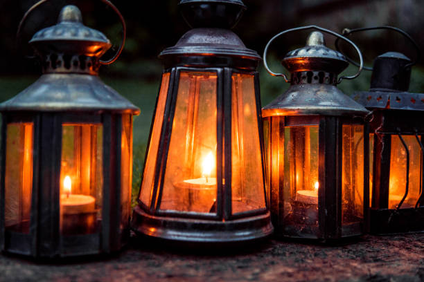 istock Close up of illuminated antique lanterns lit by candlelight in a row 887532102