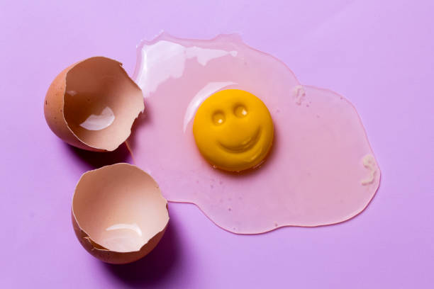 istock One chicken egg is broken and the yolk smiles. Cheerful breakfast 887558770