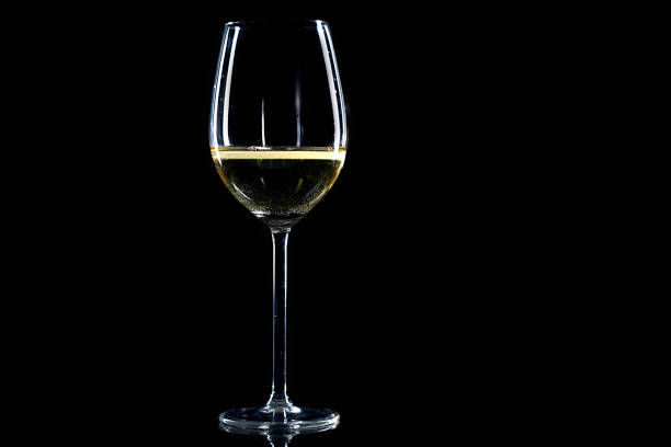 glass of white wine on black background
