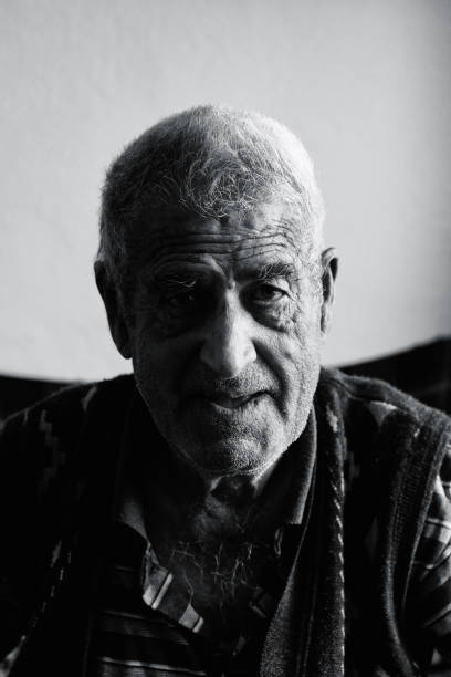 istock Old man looking at camera and talking about his memories 887564238