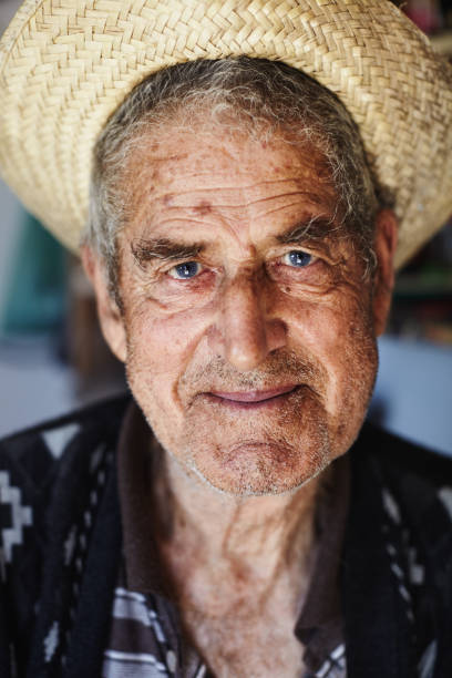 istock Old man with a straw hat and smile looking at the camera 887564296