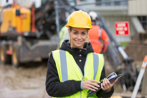 istock female construction worker managing team at building site 887588728