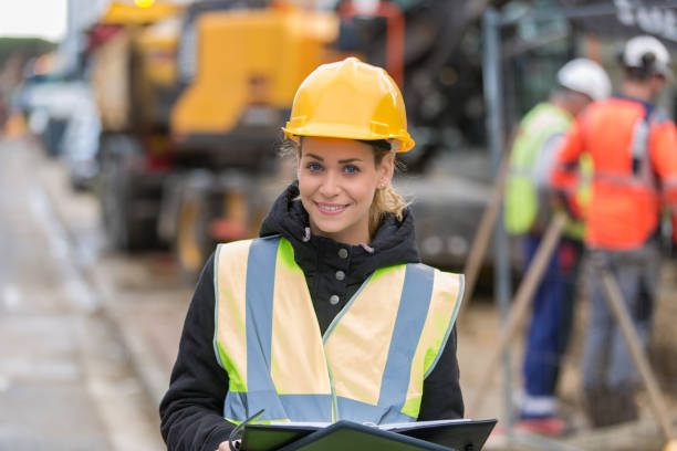 istock female construction worker managing team at building site 887588730