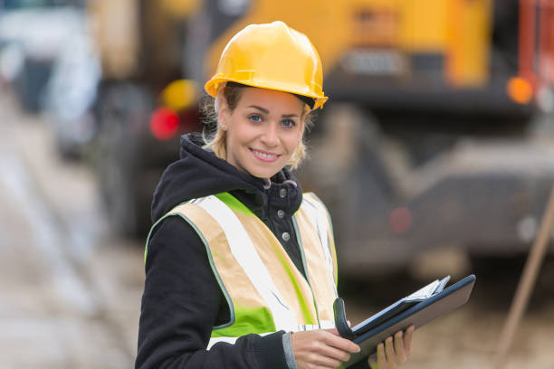 istock female construction worker managing team at building site 887588734