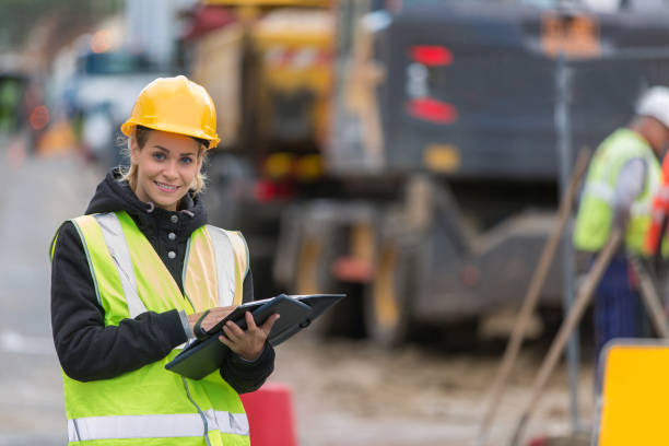 istock female builder in hardhat with tablet pac at construction with her team 887588752