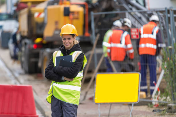 istock female builder in hardhat with tablet pac at construction with her team 887588790