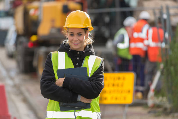 istock female construction worker working with her team and wearing hardhat 887588918
