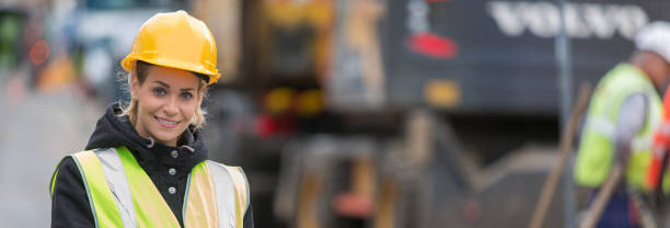 istock panoramic view of young female architect with construction team 887588942