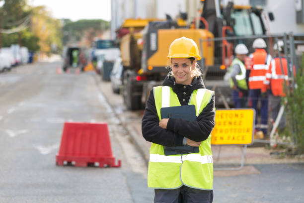 istock female construction worker working with her team and wearing hardhat 887588944