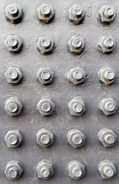 istock Bolts and nuts in rows on painted metal board 887589052