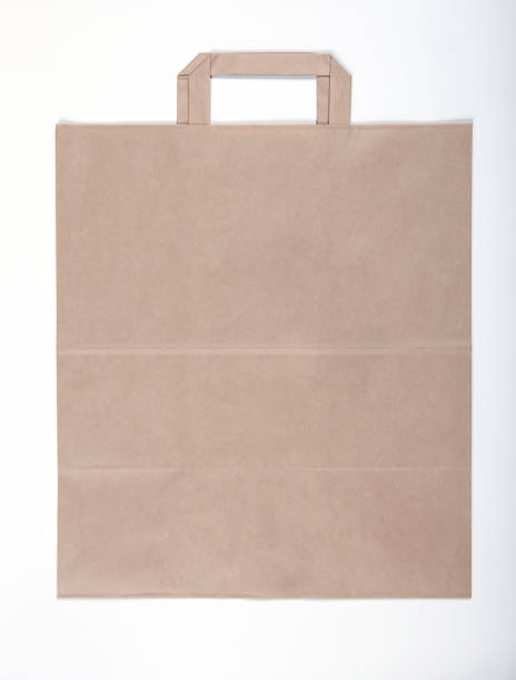 istock Beige brown kraft paper bag with handles top view flat layed 887589348