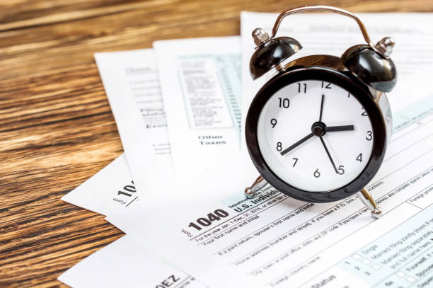 istock Tax forms with clock on the table. Business and tax concept. 887597672