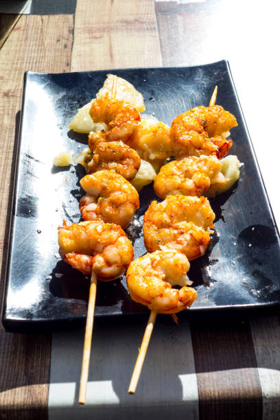 istock Tiger prawns whit potatoes on black table, spanish typical plate. 887602392