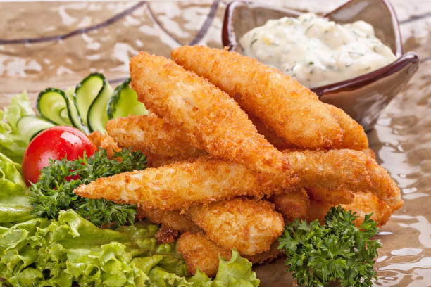 istock Pieces of fish fried in batter garnished with vegetables. 887602784