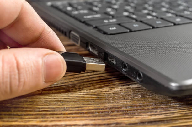 istock The human hand pushes the flash drive into a laptop. 887606608