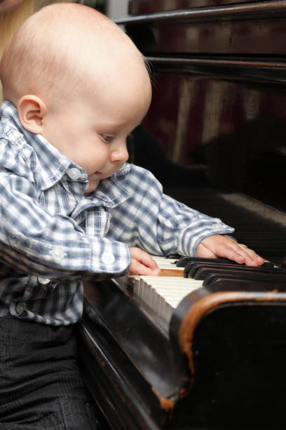 istock beautiful little baby boy plays piano 887608818