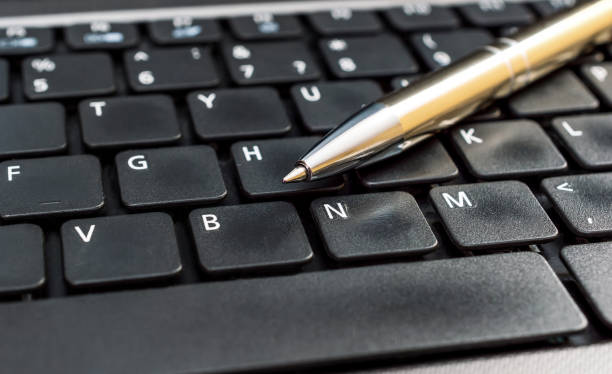 istock Pen on the laptop keyboard. Close up. 887613264