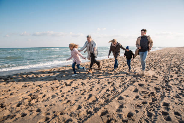 istock family walking together on seashore 887620498