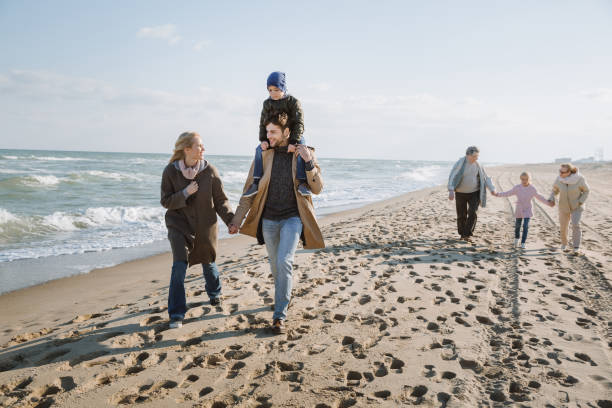 istock family walking together on seashore 887620678