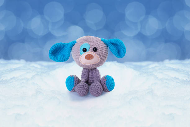 istock knitted dog on snowy background 887621478
